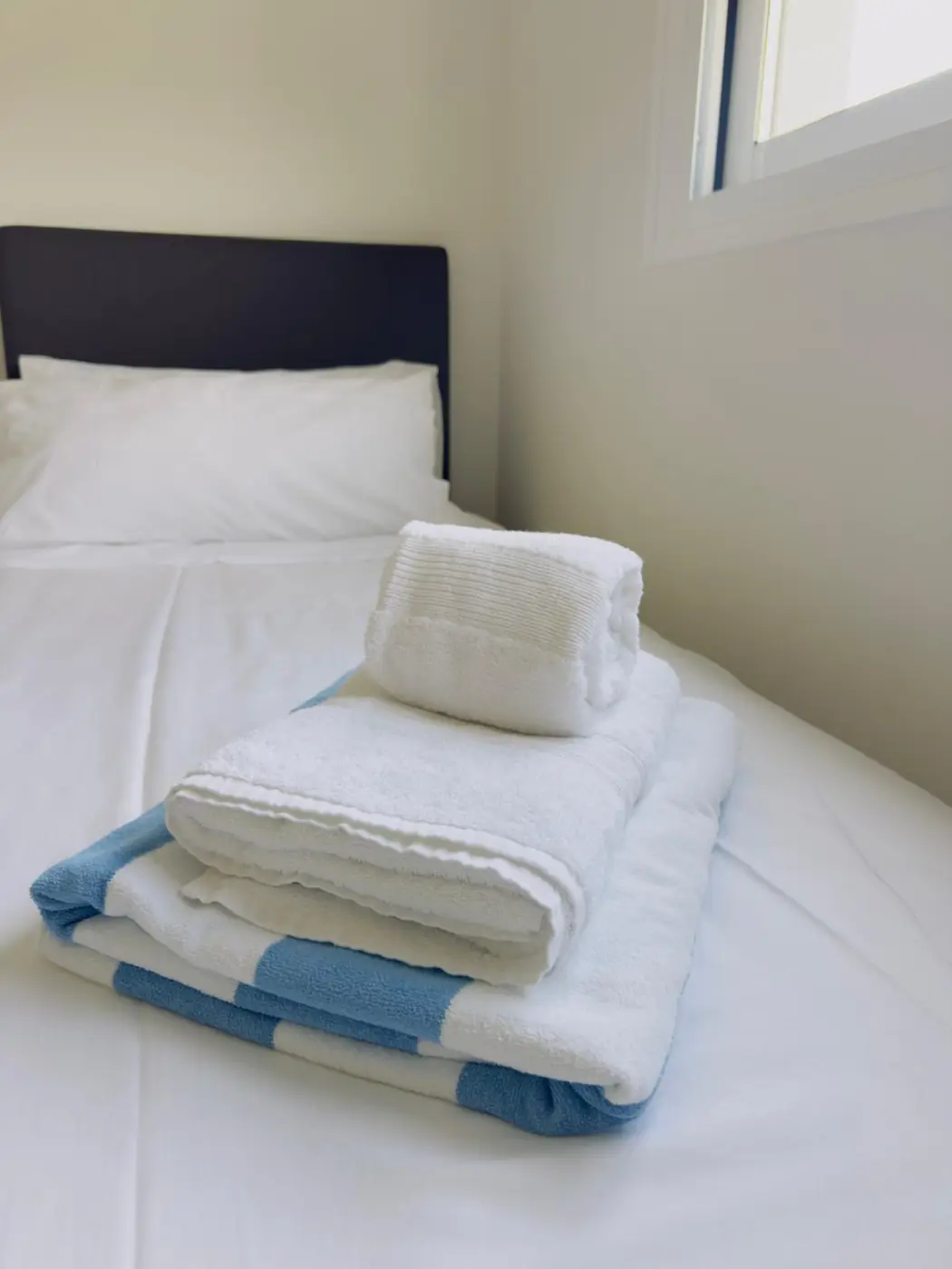 Fresh towels arranged on a prepared bed