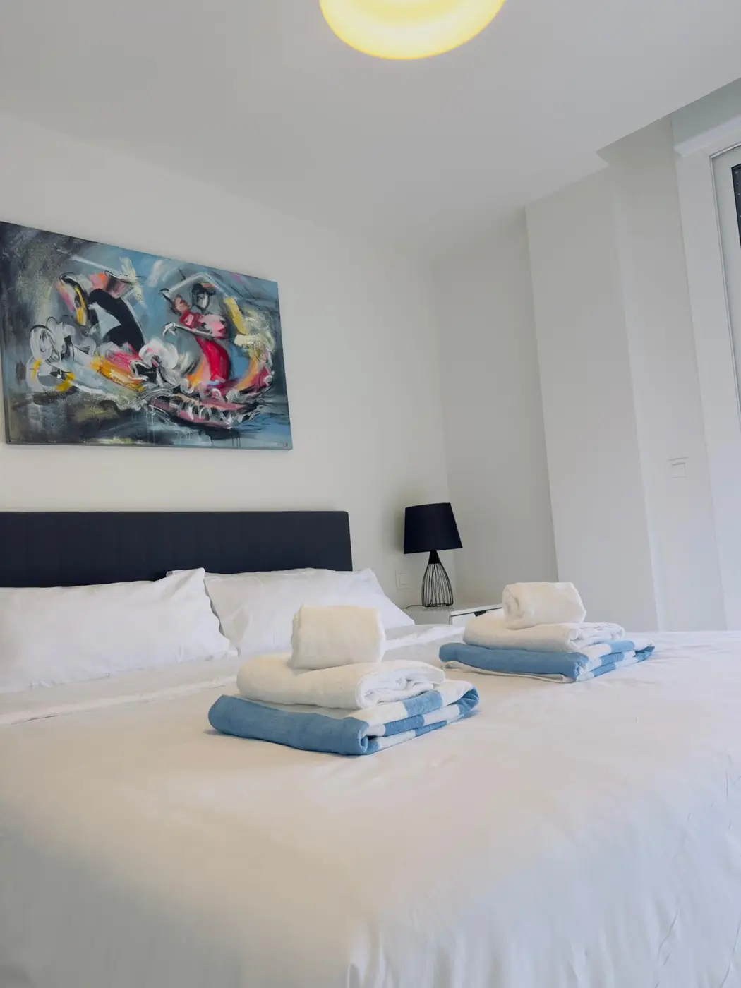 Dormitorio principal preparado con toallas dobladas