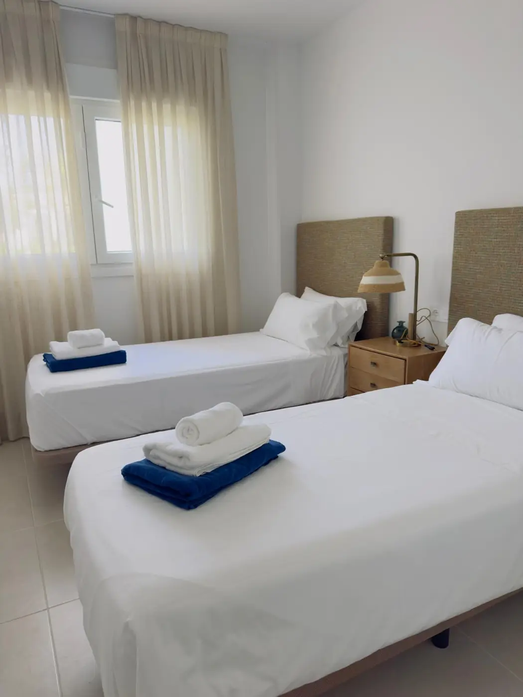 Dormitorio doble recién preparado con toallas dobladas