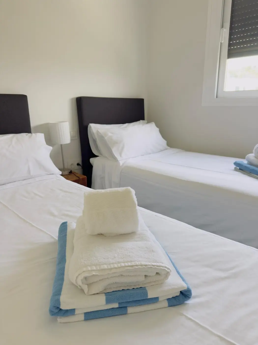 Dormitorio doble recién preparado con toallas dobladas
